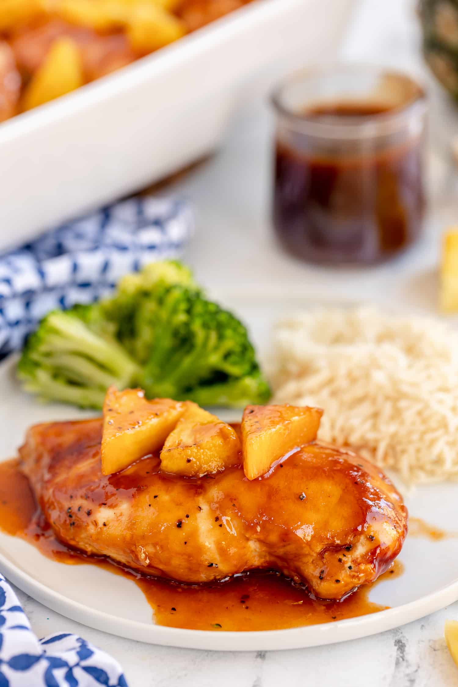 Baked BBQ Pineapple Chicken on a white plate served with white rice and broccoli