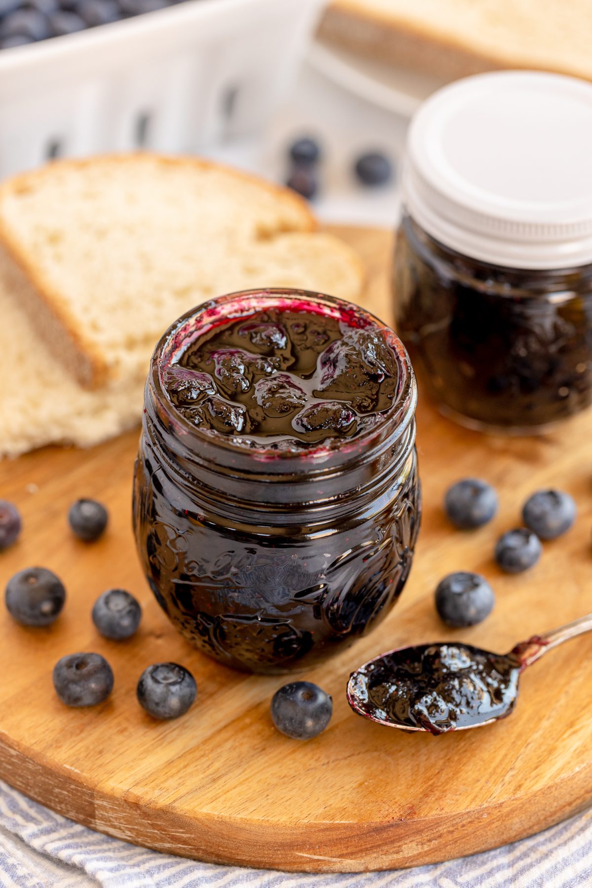 blueberry freezer jam on wood sliced with sliced bread beside